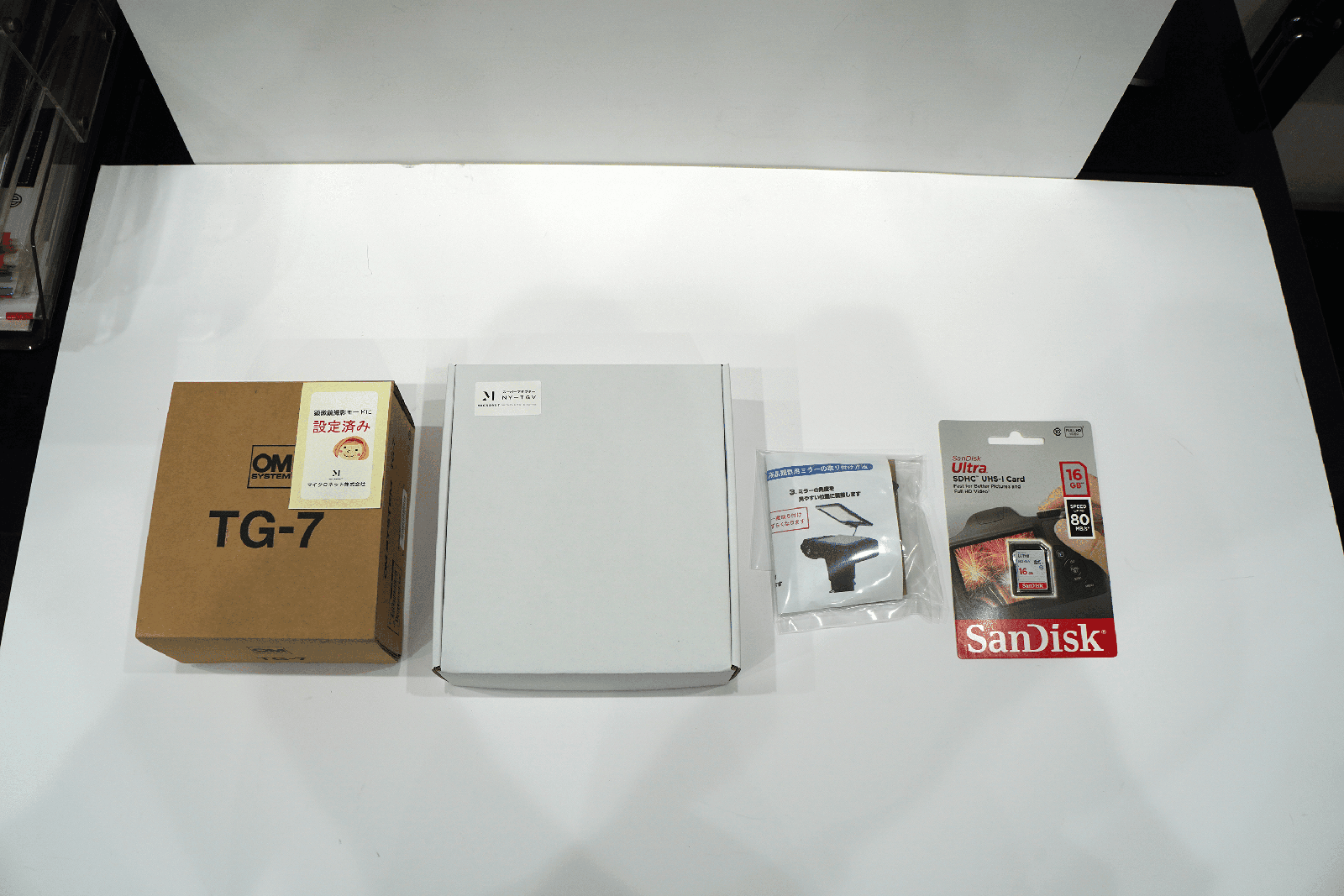 TG-7スーパーシステムの同梱物一式。茶色の箱、白い箱、小さいビニールの袋、SDカード